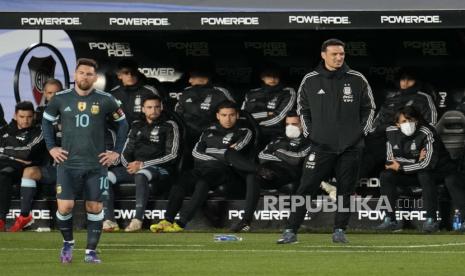  Pemain Argentina Lionel Messi berdiri di lapangan saat pelatihnya Lionel Scaloni (kanan) menonton pertandingan sepak bola kualifikasi Piala Dunia FIFA Qatar 2022 melawan Peru di Buenos Aires, Argentina, Kamis, 14 Oktober 2021. Scaloni dan Messi absen mendampingi timnas Argentina di kualifikasi Piala Dunia 2022 zona Conmebol pada Februari 2022 karena positif Covid-19.