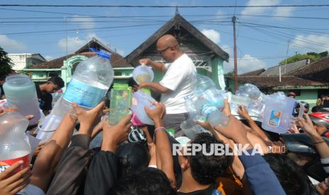 Seorang peloper susu membagikan susu sapi gratis yang tak ditampung industri kepada warga di Boyolali, Jawa Tengah, Sabtu (9/11/2024).