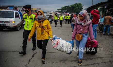 Calon penumpang menunggu bus tujuan Jakarta di terminal bayangan Gerbang Tol Cileunyi, Kabupaten Bandung, Jawa Barat, Ahad (1/11/2020). Kepala Bagian Operasi Korps Lalu Lintas Polri Komisaris Besar Rudi Antariksawan mengatakan, puncak arus balik libur panjang cuti bersama menuju Jakarta di berbagai daerah akan terjadi pada Minggu (1/11/2020) malam ini. 