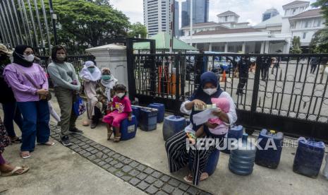 Seorang warga Muara Angke memberikan minum kepada anaknya saat melakukan aksi di depan Balai Kota DKI Jakarta, Selasa (22/2/2022). Para warga yang berasal dari Blok Limbah, Blok Eceng dan Blok Empang RW 22 Muara Angke menggelar aksi terkait krisis air bersih yang melanda di kampung mereka yang belum mendapatkan layanan air bersih sejak tahun 1980-an. Republika/Putra M. Akbar