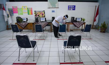 Petugas mengenakan masker dan pelindung wajah saat beraktivitas di posko Penerimaan Peserta Didik Baru (PPDB) SMP Negeri 60, Jakarta, Selasa (16/6). PPDB DKI Jakarta menyisakan 7.758 kursi kosong di jenjang SD, SMP, SMA, dan SMK. (ilustrasi)