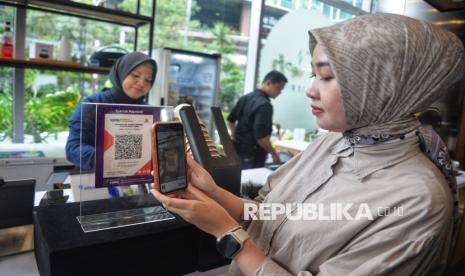 Karyawan melakukan transaksi dengan fitur pembayaran QR Muamalat DIN (MDin) di kedai kopi, Muamalat Tower, Jakarta, Kamis (14/11/2024). Hingga September 2024, volume transaksi QRIS MDin telah mencapai lebih dari Rp403 miliar atau naik 148% year on year (yoy). Kenaikan volume transaksi tersebut sejalan dengan peningkatan jumlah transaksi QRIS MDin sebesar 173% (yoy) menjadi lebih dari 2,2 juta transaksi. Adapun jumlah merchant QRIS Bank Muamalat tumbuh 49% (yoy) menjadi lebih dari 13.000 merchant.