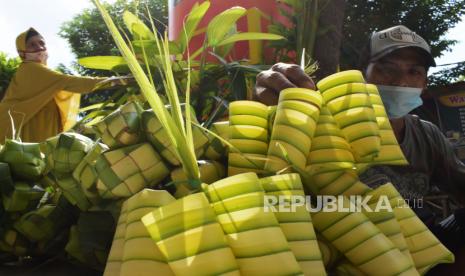 Pembuat sekaligus penjual musiman merapikan cangkang ketupat