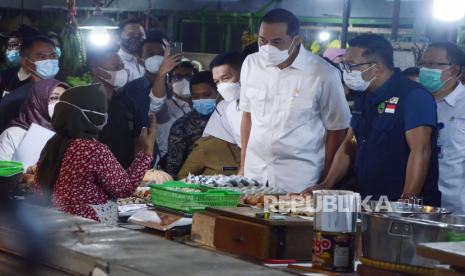 Menteri Perdagangan (Mendag) Muhammad Lutfi dan Gubernur Jawa Barat Ridwan Kamil berbincang dengan pedagang saat meninjau harga kebutuhan pokok di Pasar Kosambi, Kota Bandung, Selasa (13/4). Mendag akan melakukan pemantauan terhadap sejumlah komuditas kebutuhan pokok selama Ramadhan agar tetap terjaga stoknya dan stabil hargannya.