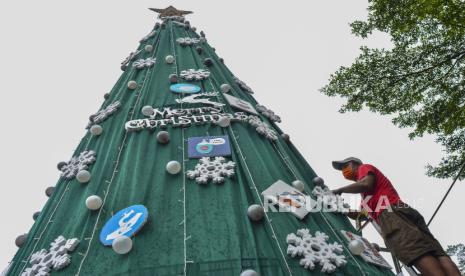 Umat Kristiani menghiasi pohon natal di Halaman Gereja Katolik Santo Yohanes, Kabupaten Ciamis, Jawa Barat, Selasa (21/12/2021). Jelang perayaan Natal Umat Kristiani membuat pohon natal yang dihiasi dengan berbagai tulisan protokol kesehatan untuk mengkampanyekan penerapan prokes mengingat Virus Corona varian Omicron sudah masuk Indonesia. 