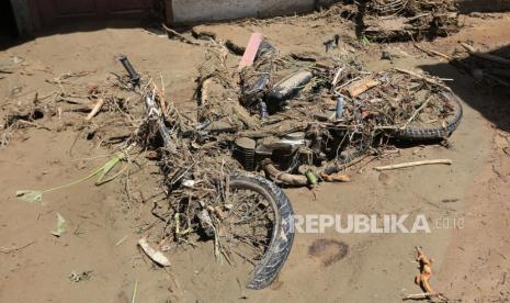 Sebuah sepeda motor tertimbun material lumpur akibat banjir bandang.