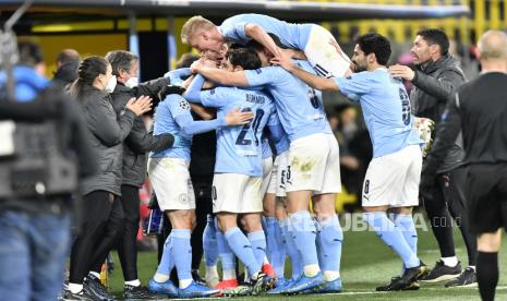 Pelatih kepala Manchester City Pep Guardiola merayakan dengan pencetak gol Manchester City Phil Foden selama pertandingan sepak bola leg kedua perempat final Liga Champions antara Borussia Dortmund dan Manchester City di stadion Signal Iduna Park di Dortmund, Jerman, Rabu, 14 April 2021. 