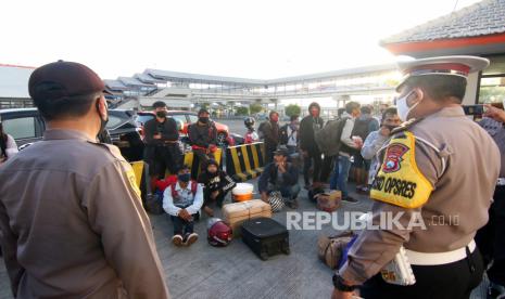 Polisi memeriksa calon penumpang travel liar yang tertahan di Pelabuhan Ketapang, Banyuwangi, Jawa Timur, Senin (18/5/2020). Polisi mengamankan sejumlah travel liar tanpa izin trayek yang akan digunakan untuk angkutan arus mudik Idul Fitri penumpang dari Bali menuju ke sejumlah daerah di Jawa