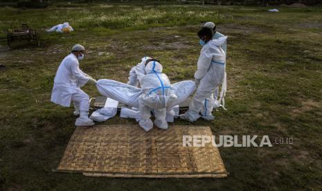  Kerabat dan pekerja kota bersiap untuk menguburkan jenazah seseorang yang meninggal karena Covid-19 di Gauhati, India, Ahad, 25 April 2021. 