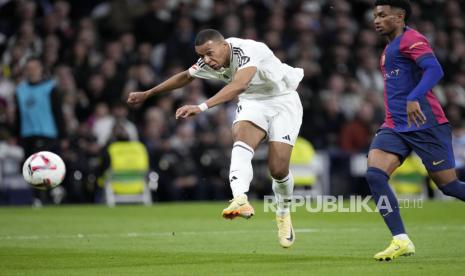 Pemain Real Madrid Kylian Mbappe melepaskan tendangan ke gawang Barcelona pada pertandingan sepak bola La Liga Spanyol di stadion Santiago Bernabeu di Madrid, Spanyol, Ahad (27/10/2024). Barcelona berhasil menaklukkan Madrid dengan skor telak 4-0. Robert Lewandowski mencetak dua gol di menit 54 dan 56. Sedangkan dua gol lainnya dicetak Lamine Yamal menit ke-77 dan Raphinha menit ke-84.