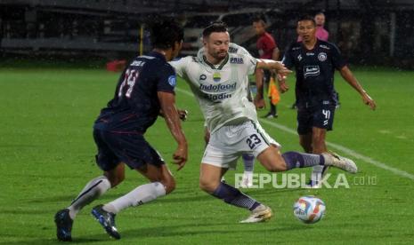 Pesepak bola Persib Bandung Marc Klok (tengah) berusaha melewati pesepak bola Arema FC Jayus Hariono (kiri) dalam pertandingan BRI Liga 1 di Stadion Kapten I Wayan Dipta, Gianyar, Bali, Jumat (7/7/2023).  