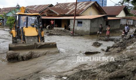 Sebuah ekskavator beraksi membersihkan lumpur dari jalan pasca banjir di Dili, Timor Leste, juga dikenal sebagai Timor Leste, 05 April 2021. Puluhan orang tewas dan puluhan hilang karena banjir dan tanah longsor akibat hujan lebat melanda bagian timur Indonesia dan Timor Leste selama akhir pekan.