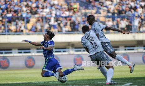 Pesepak bola Persib Bandung Daisuke Sato (kiri) berebut bola dengan pesepak bola Bali United Haudi Abdillah (tengah) pada pertandingan BRI Liga 1 di Stadion Gelora Bandung Lautan Api, Bandung, Jawa Barat, Selasa (23/8/2022). 