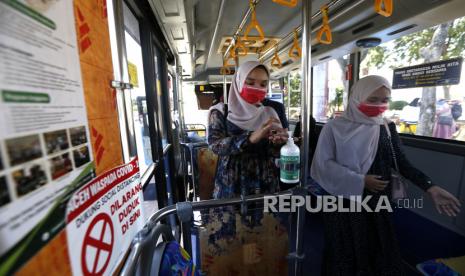 Penumpang angkutan massal Trans Koetaraja membersihkan tangan dengan cairan antiseptik (hand sanitizer) yang disediakan di dalam bus di Banda Aceh, Aceh, Ahad (23/8/2020). Angkutan massal Trans Koetaraja melaksanakan uji coba operasional setelah terhenti selama hampir lima bulan akibat pandemi COVID-19 dengan memperketat protokol kesehatan dan mengurangi jumlah penumpang. ANTARA FOTO/Irwansyah Putra/foc.