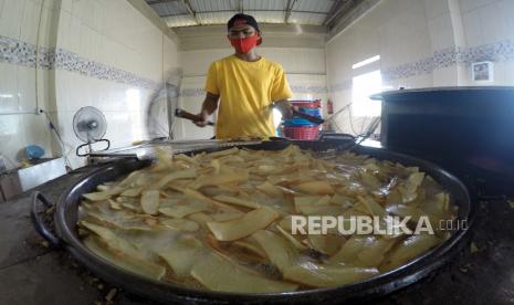 Pekerja menggoreng singkong untuk diolah menjadi keripik balado di Dapur Christine Hakim, Padang, Sumatera Barat, Jumat (16/10/2020). Usaha kripik balado yang merupakan oleh-oleh khas Kota Padang itu masih bertahan di tengah pandemi COVID-19, dengan mengurangi produksi hingga 60 persen dan memanfaatkan promosi dan penjualan secara daring. 