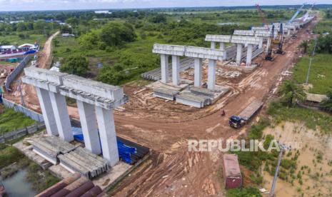 Foto udara pengerjaan proyek Jalan Tol Trans Sumatera ruas Kayu Agung-Palembang-Betung (Kapal Betung) seksi II Jalintim–Musi Landas di Desa Pulo Kerto, Gandus, Palembang, Sumatera Selatan, Kamis (16/12/2021). Progres pengerjaan Tol Kapal Betung seksi II Jalintim–Musi Landas sepanjang 24,9 km telah mencapai 33,68 persen,  seksi III Musi Landas-Betung sepanjang 44,29 km telah mencapai 6,71 persen sedangkan untuk pembebesan lahan secara keseluruhan telah mencapai 85,86 persen atau 1.694 bidang.