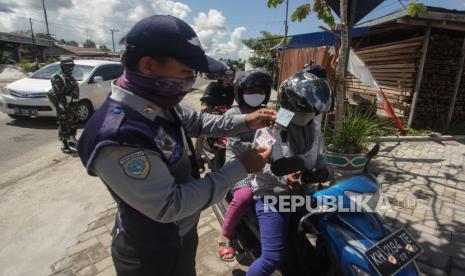 Petugas Dishub memeriksa identitas pengguna kendaraan bermotor di Jalur Trans Kalimantan Pahandut Sebrang, Palangkaraya, Kalimantan Tengah, Senin (11/5/2020). Pada pemberlakuan hari pertama Pembatasan Sosial Berskala Besar (PSBB), petugas gabungan dari Dishub, Polri, TNI dan Satpol PP memperketat akses kendaraan yang akan memasuki Kota Palangkaraya