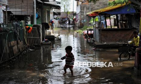 Anak bermain di sisa genangan bekas banjir di kawasan Kampung Sepatan, Cilincing, Jakarta utara, Jumat (31/1/2025). Warga Kampung Sepatan, RT 18/05, Rorotan, Cilincing memanfaatkan kontainer atau peti kemas yang kosong untuk dijadikan tenpat mengungsi sementara setelah kediamannya terendam banjir setinggi satu meter. Sebanyak 8 unit peti kemas sempat dijadikan warga sebagai tempat pengungsian, namun kini hanya tersisa 3 peti kemas yang diisi warga dan sebagian pengungsi telah kembali ke kediamannya ketika banjir berangsur surut.