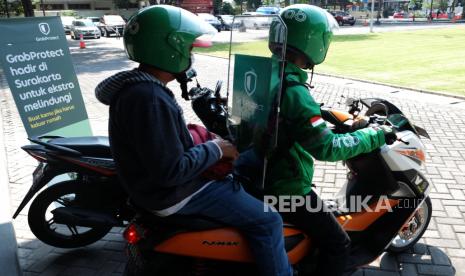 Penumpang menggunakan layanan ojek daring (ojol) yang dilengkapi fasilitas separator khusus di Balai Kota Solo, Jawa Tengah, Senin (8/6/2020). Untuk menyambut normal baru, Grab Indonesia melengkapi pengemudi di Soloraya dengan fasilitas separator guna memberikan kenyamanan dan keamanan dalam berkendara di tengah pandemi COVID-19