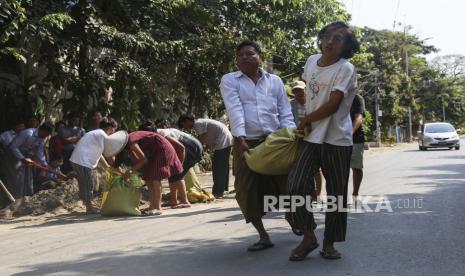  Orang-orang membawa kantong pasir saat mereka membangun penghalang jalan darurat untuk mencegah pasukan keamanan memasuki daerah di Mandalay, Myanmar, 05 Maret 2021. Protes anti-kudeta terus berlanjut pada 05 Maret meskipun tindakan keras terhadap demonstran semakin meningkat oleh pasukan keamanan. Lebih dari 50 orang tewas dalam tindakan keras oleh pasukan keamanan, sejak kudeta militer pada 1 Februari 2021.