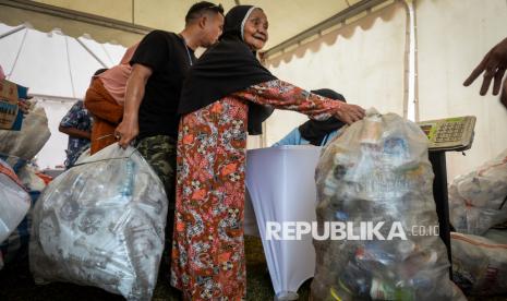 Warga meletakan sampah ke timbangan saat kegiatan Sembako Tukar Sampah di Alun-alun Teluk Naga, Kabupaten Tangerang, Banten, Selasa (4/2/2025). Kegiatan penukaran sampah rumah tangga yang sudah dipisahkan jenisnya dengan sembako tersebut untuk mengedukasi warga pentingnya pengelolaan sampah dalam pengembangan ekonomi sirkular. 