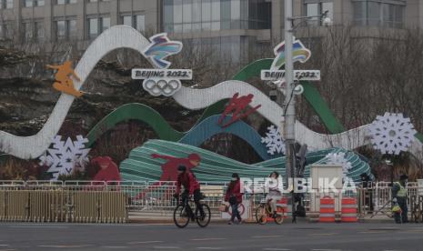  Orang-orang mengendarai sepeda di dekat dekorasi untuk Olimpiade Musim Dingin Beijing, di Beijing, Cina, 24 Januari 2022. Cina dijadwalkan menjadi tuan rumah Olimpiade dan Paralimpiade Musim Dingin Beijing 2022 pada bulan Februari, menjadikan ibu kotanya kota pertama di dunia yang menjadi tuan rumah kedua Musim Panas ( 2008) dan Olimpiade Musim Dingin (2022).