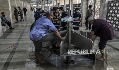 Sejumlah umat Muslim mengambil air wudhu sebelum melaksanakan Shalat Jumat berjamaah di Masjid Istiqlal, Jakarta, Jumat (20/8). Masjid Istiqlal kembali dibuka untuk kegiatan ibadah Shalat Jumat dengan melaksanakan protokol kesehatan yang ketat, kapasitas maksimal 25 persen dan jamaah harus sudah divaksin Covid-19. Republika/Putra M. Akbar