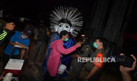 Anggota Satpol PP berdialog dengan pengamen ondel-ondel disela razia penerapan Pembatasan Sosial Berskala Besar (PSBB) total di kawasan Bendungan Hilir, Jakarta, Senin (14/9/2020) malam. Razia tersebut untuk memastikan masyarakat mematuhi aturan yang berlaku selama PSBB total DKI Jakarta. ANTARA FOTO/Sigid Kurniawan/hp.