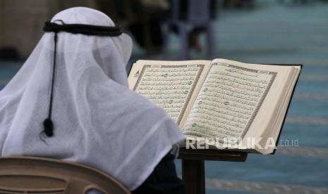 Seorang lelaki tua membacakan ayat-ayat Alquran, kitab suci umat Islam, sambil menunggu berbuka puasa di masjid Al-Omari selama bulan suci Ramadhan di Kota Gaza, Rabu, 13 April 2022. Hukum Menaruh Tulisan Ayat Alquran dalam Kalung untuk Mencari Berkah