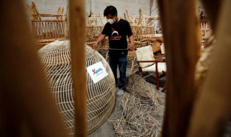 Perajin tengah mengerjakan tahapan terakhir pembuatan kursi rotan di workshop produksi kerajinan rotan Aryasena di kawasan Gatak, Sukoharjo, Jawa Tengah, Senin (22/11/2021). (Sufri Yuliardi)