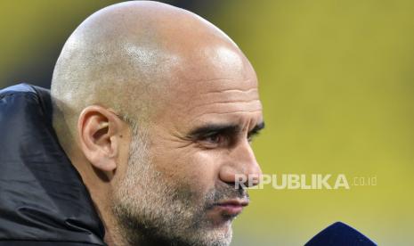 Pelatih kepala Manchester City Pep Guardiola meringis saat pernyataan media sebelum pertandingan sepak bola leg kedua perempat final Liga Champions antara Borussia Dortmund dan Manchester City di stadion Signal Iduna Park di Dortmund, Jerman, Rabu, 14 April 2021. 