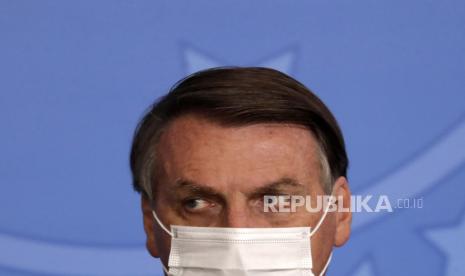 Presiden Brasil Jair Bolsonaro, mengenakan topeng untuk mengekang penyebaran COVID-19, menghadiri upacara peluncuran Program Raksasa Aspal, di istana kepresidenan Planalto, di Brasilia, Brasil, Selasa, 18 Mei 2021. 