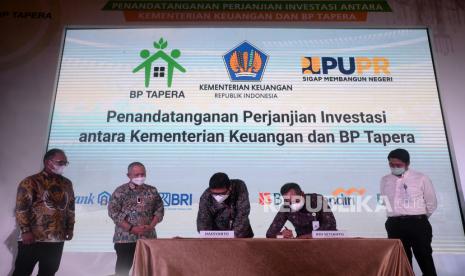 Komisioner BP Tapera Adi Setianto (dua kanan) bersama Dirjen Perbendaharaan Kementerian Keuangan Hadiyanto ( tiga kiri) melakukan penandatanganan perjanjian investasi antara Kementerian Keuangan dan BP Tapera disaksikan Direktur Jenderal Pembiayaan Infrastruktur Pekerjaan Umum dan Perumahan Kementerian PUPR Herry Trisaputra Zuna (dua kiri), Kepala Departemen Pengawasan Industri Keuangan Non Bank (IKNB) 2B Otoritas Jasa Keuangan (OJK) Bambang W. Budiman (kiri) dan Sekretaris Direktorat Jenderal Pembinaan Hubungan Industrial dan Jaminan Sosial Tenaga Kerja Kementerian Ketenagakerjaan Surya Lukita Warman (kanan) di Jakarta, Rabu (22/12). BP Tapera resmi bertindak sebagai Operator Investasi Pemerintah (OIP) dalam menyalurkan dana Fasilitas Likuiditas Pembiayaan Perumahan (FLPP) pada tahun 2022. BP Tapera akan menyalurkan KPR Sejahtera FLPP sebesar Rp22 triliun atau setara dengan 200 ribu unit rumah pada tahun depan.Prayogi/Republika.