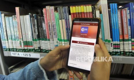 Petugas menunjukan aplikasi iSumbar Mambaco  sebagai layanan pustaka digital di Perpustakaan Daerah Sumatera Barat, di Padang, Sumatera Barat, Jumat (7/8/2020). Dinas Kearsipan dan Perpustakaan Provinsi Sumatera Barat meluncurkan aplikasi pustaka digital iSumbar Mambaco untuk mempermudah masyarakat membaca buku atau mencari informasi di perpustakaan umum selama pandemi COVID-19 tanpa harus keluar rumah.