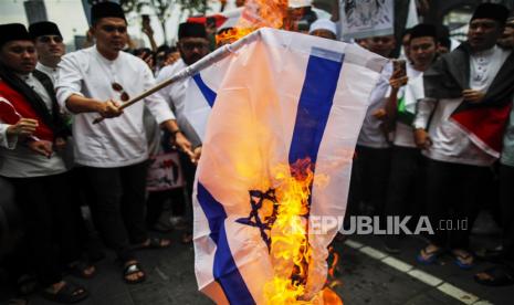 Pengunjuk rasa membakar bendera Israel selama protes solidaritas dengan warga Palestina setelah polisi Israel menggerebek Masjid Al Aqsa selama Ramadhan, di Kuala Lumpur, Malaysia, 7 April 2023. Polisi Israel menyerbu Masjid Al Aqsa di Yerusalem selama sholat tarawih pada 5 April 2023 dan menangkap ratusan warga Palestina. Desakan Negara Islam Bersatu Menentang Israel Menguat di Malaysia