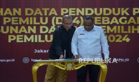 Ketua KPU Hasyim Asyari bersama Wakil Menteri Dalam Negeri John Wempi Wetipo bersip menandatangani berita acara dalam acara Penyerahan Data Penduduk Potensial Pemilih Pemilu (DP4) di Kantor KPU RI, Jakarta, Rabu (14/12/2022). DP4 tersebut digunakan sebagai bahan penyusunan daftar pemilih untuk Pemilu 2024. Republika/Prayogi. 