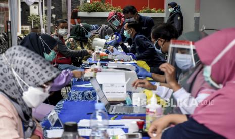 Sejumlah tenaga kesehatan mengikuti tahap verifikasi dan pemeriksaan kesehatan sebelum disuntik vaksin Covid-19 saat vaksinasi Covid-19 massal di Poltekkes Kemenkes Bandung, Jalan Pajajaran, Kota Bandung, Ahad (31/1). Sedikitnya 3.300 tenaga kesehatan serta sumber daya manusia (SDM) di lingkungan kesehatan Provinsi Jawa Barat mengikuti vaksinasi Covid-19 secara massal dan serentak di 24 fasilitas kesehatan sebagai upaya percepatan capaian target vaksinasi Covid-19. Foto: Abdan Syakura/Republika