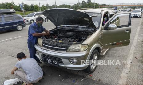 Seorang teknisi memperbaiki mobil milik pemudik yang mengalami kerusakan di pinggir ruas Jalan Tol Cikopo-Palimanan, Subang, Jawa Barat, Kamis (28/4/2022). 