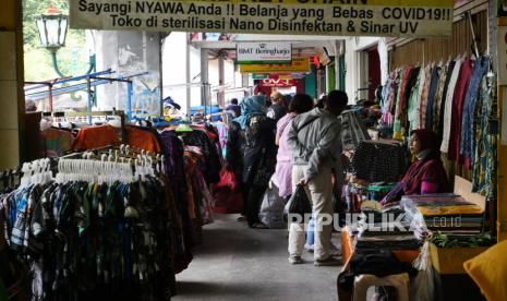 Pedagang melayani pembeli cenderamata di kawasan pedagang kaki lima Malioboro, Yogyakarta, Ahad (5/12). Pemerintah Daerah (Pemda) DIY bersama Pemerintah Kota (Pemkot) Yogyakarta berencana melakukan penataan pedagang kaki lima (PKL) yang berada di sepanjang trotoar Malioboro. Direncanakan, relokasi PKL Malioboro ini akan dilakukan pada awal 2022. Lokasi relokasi PKL Malioboro nantinya di eks gedung Bioskop Indra dan eks Gedung Dinas Pariwisata Yogyakarta.