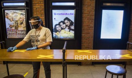 Pekerja memasang tanda jaga jarak saat simulasi pembukaan dan peninjauan tempat hiburan bioskop CGV Cinemas. DKI Jakarta memastikan bioskop belum bisa dibuka pada 29 Juli mendatang.