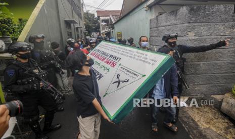 Sejumlah warga membawa plang atribut FPI di Jalan Petamburan III, Jakarta, Rabu (30/12). Aparat gabungan dari TNI dan Polri mendatangi kawasan Petamburan III untuk mencabut sejumlah atribut FPI pasca pembubaran organisasi tersebut oleh pemerintah. Republika/Putra M. Akbar