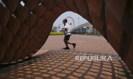 Seorang pria joging di sebuah taman di Hong Kong, Kamis, 5 Mei 2022. Hong Kong pada Kamis membuka kembali pantai dan kolam renang dalam pelonggaran pembatasan COVID-19, sementara ibu kota China, Beijing, mulai melonggarkan aturan karantina bagi pendatang dari luar negeri.