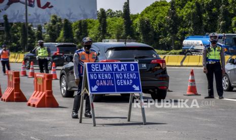 Petugas gabungan berjaga saat pemberlakuan ganjil genap di gerbang keluar Tol Pasteur, Kota Bandung, Jumat (3/9). Dinas Perhubungan (Dishub) Kota Bandung bersama Satuan Lalu Lintas (Satlantas) Polrestabes Bandung memberlakukan sistem ganjil genap di lima akses tol masuk Kota Bandung yang berlaku mulai Jumat (3/9) hingga Ahad (5/9), dengan tujuan untuk menekan mobilitas masyarakat guna meminimalisir penyebaran Covid-19 di masa PPKM. Foto: Republika/Abdan Syakura