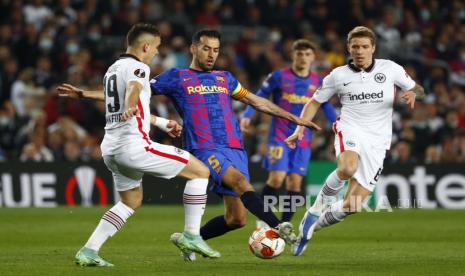  Pemain Barcelona Sergio Busquets, tengah, ditantang oleh pemain Frankfurt Rafael Santos Borre, kiri, dan pemain Frankfurt Kristijan Jakic selama pertandingan sepak bola Liga Europa, leg kedua, perempat final antara Barcelona dan Eintracht Frankfurt di stadion Camp Nou, di Barcelona, ??Spanyol, Kamis, April 14, 2022.