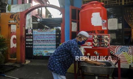 Warga mencuci tangan sebelum memasuki pemukiman saat pemberlakuan pembatasan kegiatan masyarakat (PPKM) skala mikro hari pertama di kawasan Menteng, Jakarta, Selasa (9/2). Pemerintah mulai menerapkan PPKM skala mikro mulai 9-22 Februari 2021 untuk tujuh provinsi yakni DKI Jakarta, Jawa Barat, Banten, Jawa Tengah, Yogyakarta, Jawa Timur, dan Bali. Republika/Putra M. Akbar