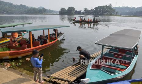 Pengunjung menaiki perahu wisata di kawasan Situ Ciburuy, Padalarang, Kabupaten Bandung Barat, Jawa Barat, Ahad (30/4/2023). Objek wisata Situ Ciburuy yang menawarkan pemandangan alam danau dan berbagai wahana permainan tersebut menjadi destinasi wisata yang ramai dikunjungi masyarakat saat libur Lebaran.