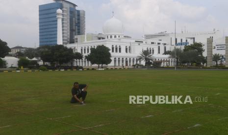 Pekerja membuat garis saf shalat Idul Fitri di Masjid Al Azhar, Jakarta, Rabu (11/5/2021). Masjid Al Azhar akan menggelar shalat idul Fitri di lapangan masjid tersebut dengan protokol pencegahan COVID-19 yang ketat. 