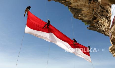 SDM Kunci Indonesia Emas 2045. Foto:   Para pemanjat tebing mengibarkan bendera raksasa di tebing batu saat upacara memperingati Hari Kemerdekaan Indonesia ke-77 di kawasan pantai Lhok Nga, Aceh Besar, Indonesia, 17 Agustus 2022. Indonesia memperoleh kemerdekaannya pada tahun 1945.