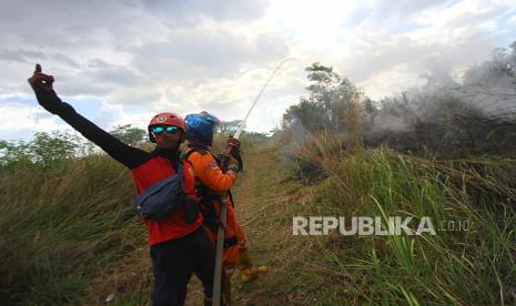 Petugas Badan Penanggulangan Bencana Daerah (BPBD) Kalimantan Selatan berupaya memadamkan api yang membakar semak belukar di Banjarbaru, Kalimantan Selatan, Jumat (18/9/2020). Kebakaran hutan dan lahan (karhutla) di Kalimantan Selatan mulai marak terjadi dalam beberapa hari belakangan ini akibat faktor cuaca panas serta angin kencang yang terjadi di sejumlah kabupaten dan kota. 