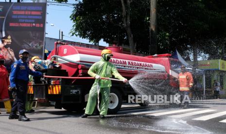 Petugas gugus tugas penanganan COVID-19 menyemprotkan disinfektan saat pembukaan kembali jalur utama kota Magelang, Jawa Tengah, Rabu (10/6/2020). Pembukaan jalan utama yang ditutup selama sekitar tiga bulan akibat pandemi COVID-19 tersebut dalam rangka menuju normal baru agar perekonomian masyarakat kembali bangkit